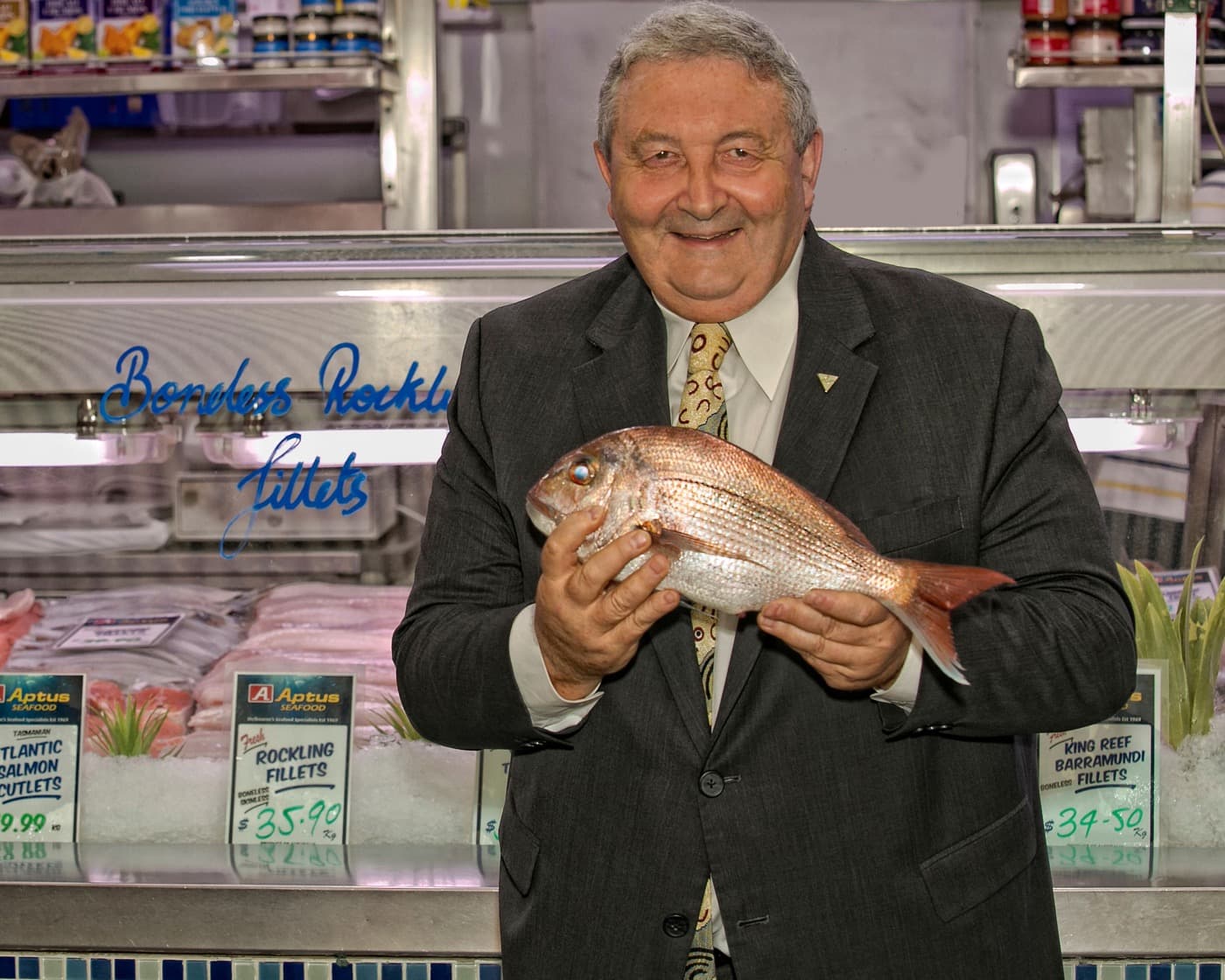 Roy Palmer holding a fish at a market counter